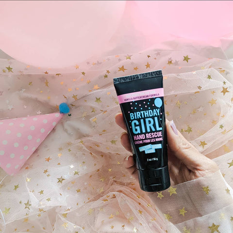 Hand holding a tube of 'Birthday Girl' hand rescue cream with festive background