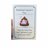 A collection of inspirational charms with humorous and supportive messages, including a blue bra charm, a potato with a sunburn, a taco, and a pickle. 