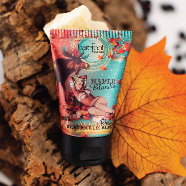 Maple scented hand balm tube with colorful pin-up style packaging on a wooden surface with a maple leaf