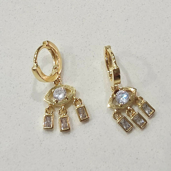 Gold earrings with gemstones on a light gray background