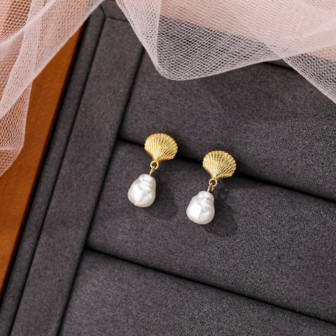 Pearl earrings with gold accents on a gray surface