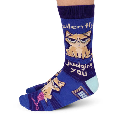 blue socks with cat images and text that reads "silently judging you"