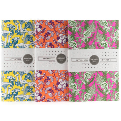 Set of notebooks with colorful floral and nature-themed designs on a white background.