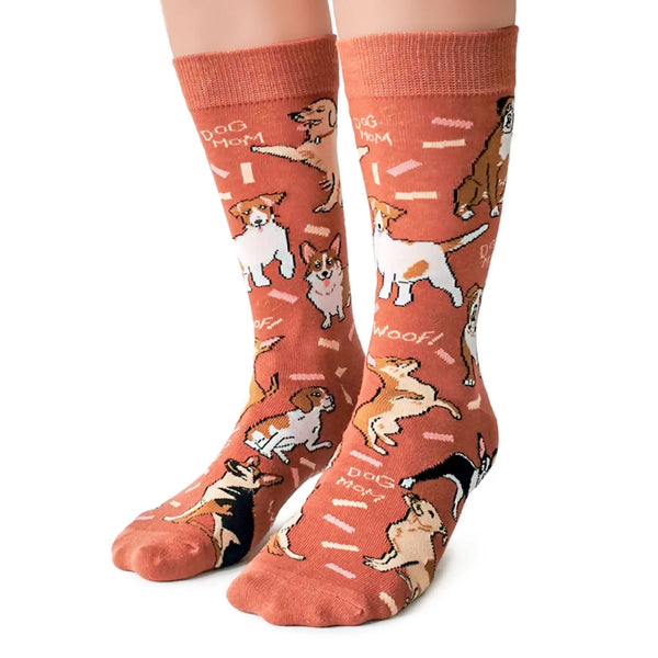 A pair of socks with various dogs and the phrases 'Dog Ma' and 'Woof!' printed on them, in a terracotta color.
